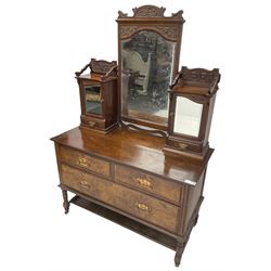 Late Victorian walnut dressing table, raised mirror back with foliate carved pediment and bevelled plate, flanked by raised cupboard with mirror doors over trinket drawers, base fitted with two short over one long drawer, on turned supports with castors