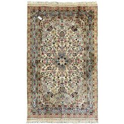 Persian design ivory ground rug, overall floral design with shaped central medallion, the main border decorated with trailing flower head pattern, within guard stipes 