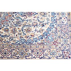 Persian Nain ivory ground rug, the busy oval field profusely decorated with scrolling foliate decoration and palmettes in citrine and indigo tones, the central medallion with matching spandrels, the multiple guard bands with repeating stylised quatrefoil motifs and trailing scrolling foliage and flowerheads