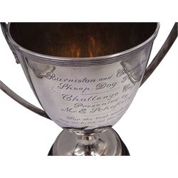 George III silver trophy cup, with reed border to rim and twin handles with acanthus leaf mounts, upon knopped stem and stepped circular foot, each with reed detailing, the body with presentation engraving 'Burniston and Cloughton Sheep Dog Trials Challenge Cup, presented by Mr E Schofield, for the best working dog or bitch at the meeting, to be won three times in succession or five times in all', with former winners engraved verso, hallmarked Henry Chawner, London 1788, upon ebonised wooden base with engraved winners plaque,  including plinth and handles H31.8cm
