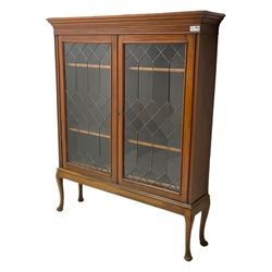 Early 20th century walnut display cabinet, projecting moulded cornice over two lead glazed doors, the interior fitted with three adjustable shelves, on cabriole supports