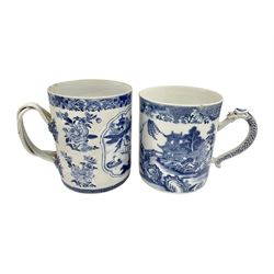 Two large 18th century Chinese blue and white tankards, each of cylindrical form, the first example with foliate mounted strap handle, the body painted with a shaped panel depicting a riverside landscape with pagodas and pine trees, against a textured ground decorated with floral sprays, H15cm D12cm, the second with serpent handle, the body painted with a similar riverside landscape, H14cm D12cm