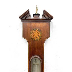 Early 19th century William IV mercury wheel barometer with a rosette inlaid broken pediment and correspondingly inlaid round base, mahogany veneered case with inlaid oval conch shell paterae and satinwood stringing to the edge, with an arched thermometer box and spirit thermometer measuring degrees Fahrenheit from 20 to 120, eight-inch silvered register reading barometric pressure in inches from 28  to 31, with predictions in Roman upper and lower case and script, dial inscribed “A Tagliabue,24 Grenville Street, Luther Lane, London”, with a steel indicating hand, brass recording hand and cast brass bezel.