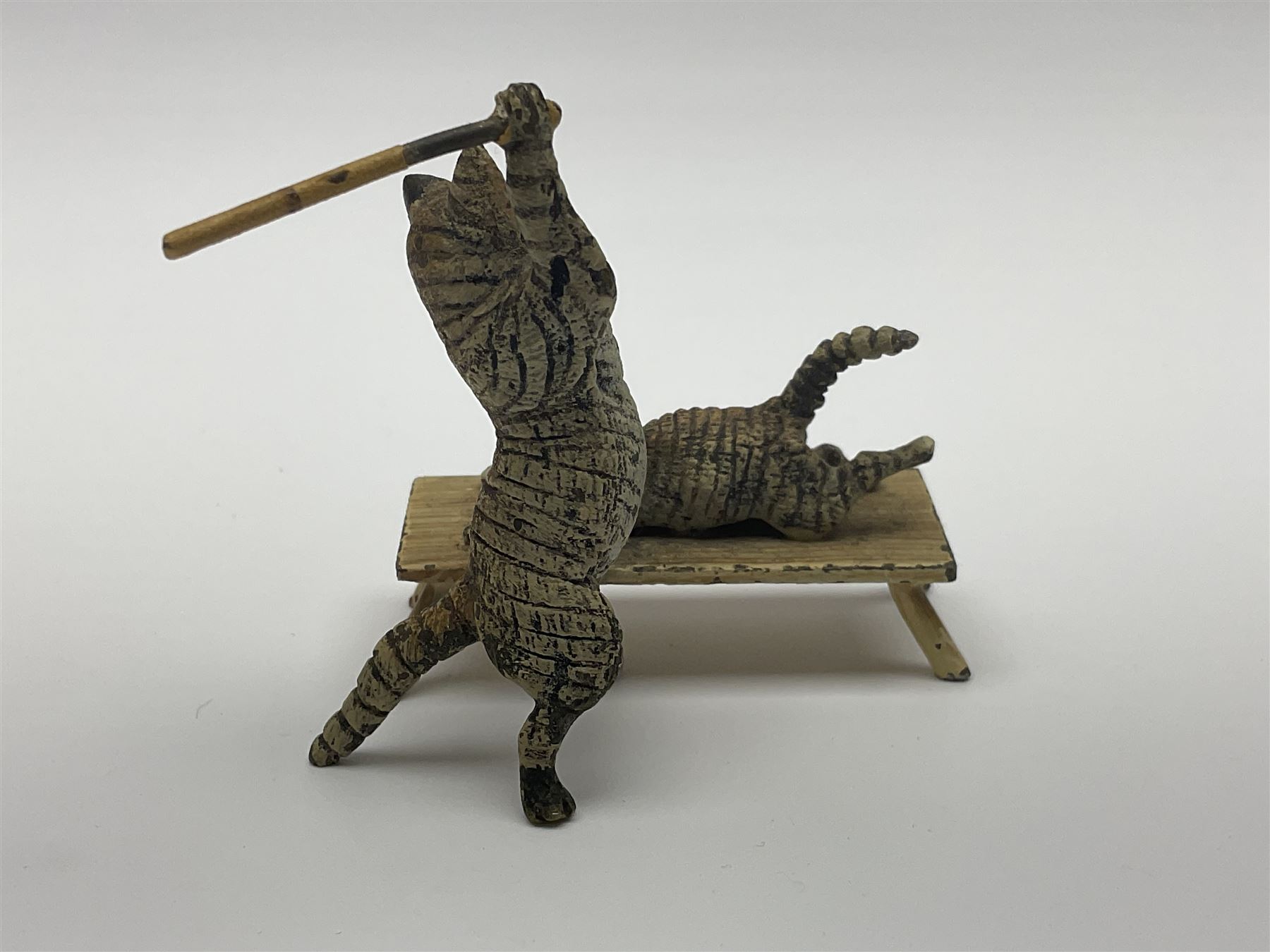 After Bergmann, two cold painted bronze figures, the first modelled as two cats on a bench hugging, the second a cat caning a kitten