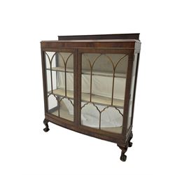 Early 20th century mahogany bow front display cabinet, fitted with two astragal glazed doors with arch pains and glass panelled sides, enclosing two shelves, raised on cabriole supports with ball and claw feet 