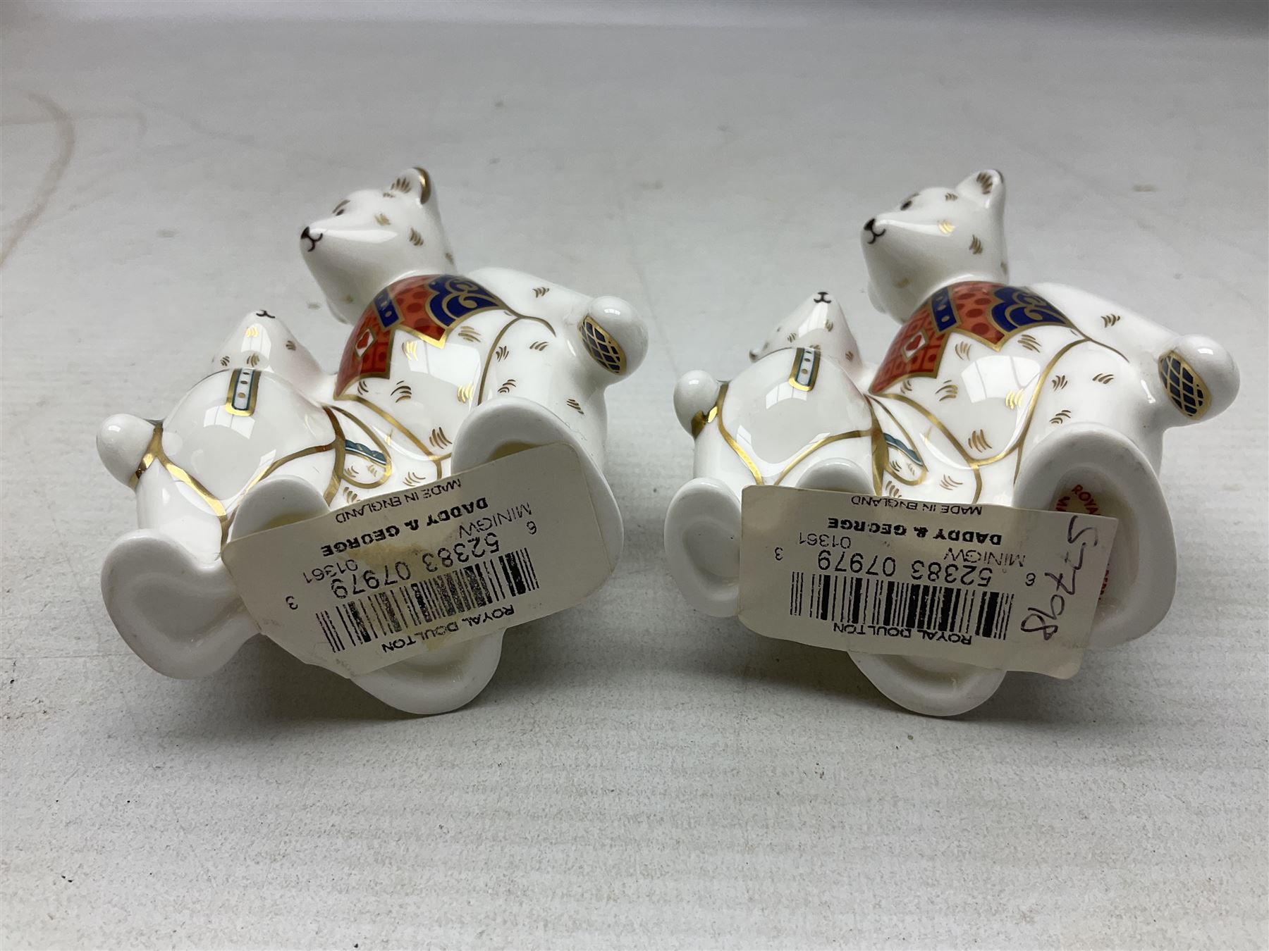 Four Royal Crown Derby teddy paperweights, comprising Teddy Cook, two Teddy George and Seated Teddy, all without stoppers, together with Crown Namestake with gold stopper 