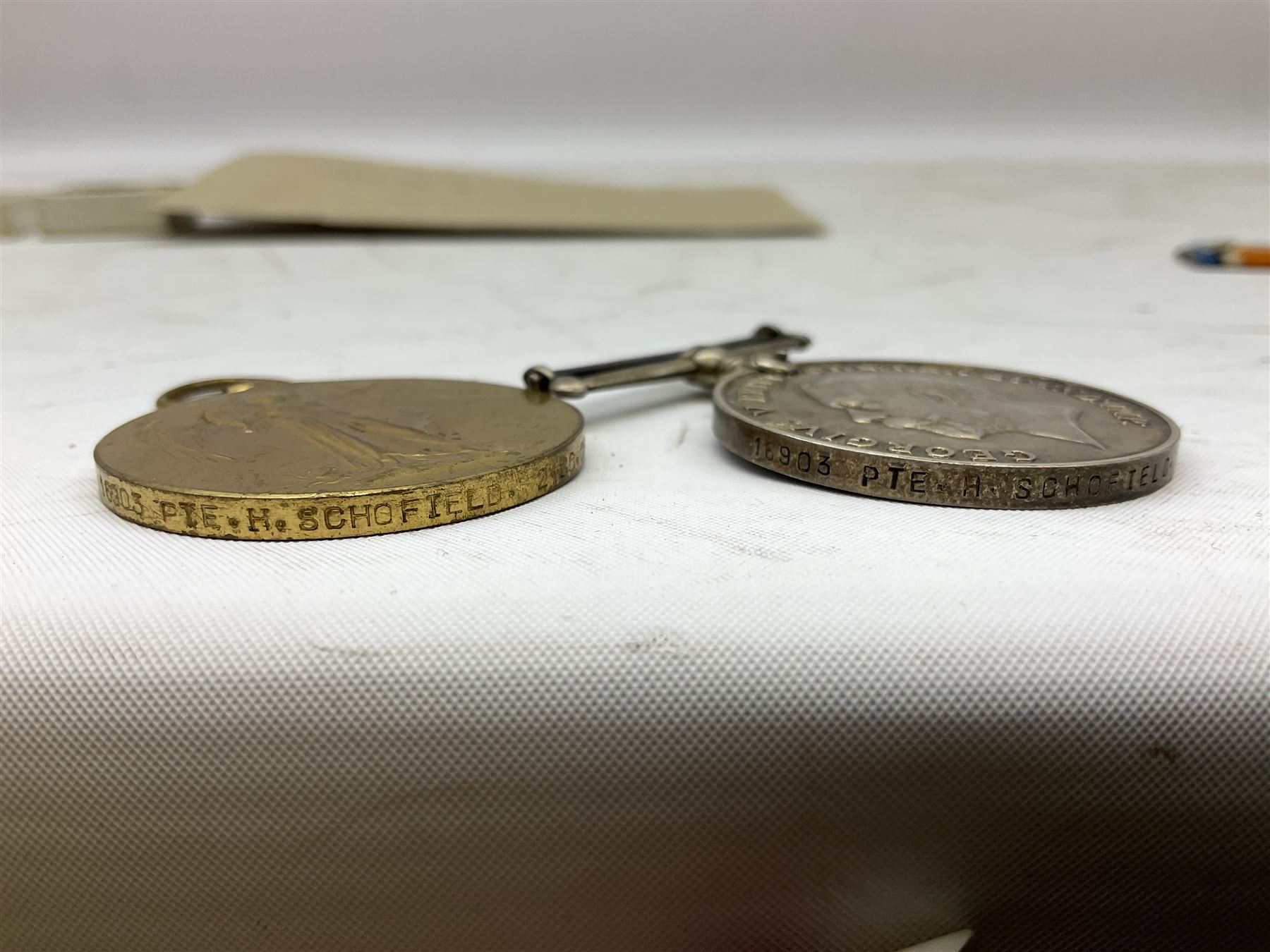 Mostly Great British coins including Queen Victoria 1887 and 1888 crowns, pre-decimal coinage, various five pound coins etc and a WWI War and Victory medal pair named to '16903 PTE. H. SCHOFIELD. 2-CO. OF LOND. Y.'