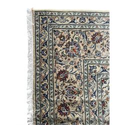 Persian Kashan ivory ground carpet, the field decorated with interlacing foliate branches and stylised plant motifs, scrolling border decorated with repeating palmettes, within floral pattern guard bands