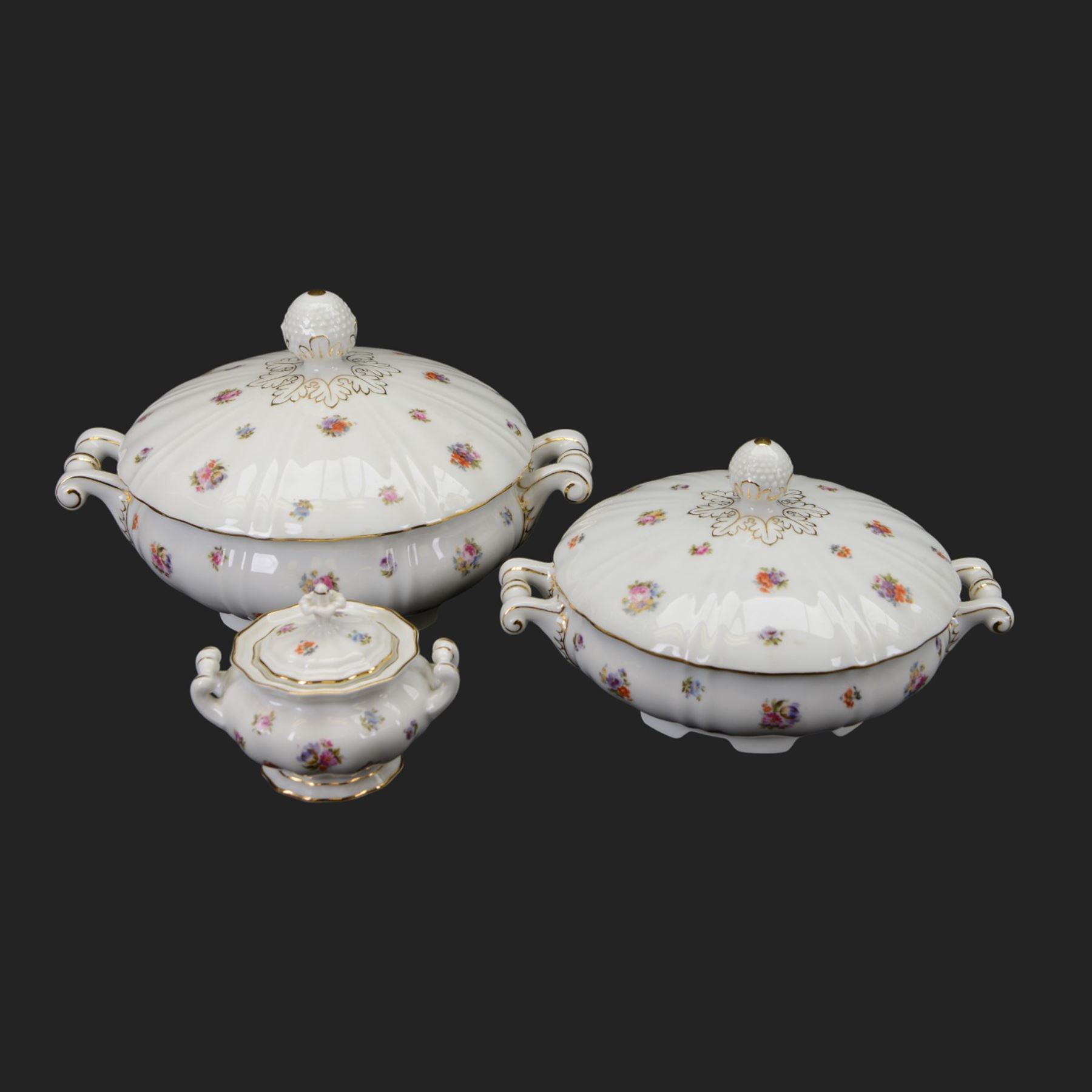 Forstenberg part tea and dinner service, comprising teapot, teacups and saucers, dinner plates, tureens, sauce boat, lidded sugar bowl, side plates and serving plates, all decorated with polychrome floral sprigs on a white ground with gilt edging