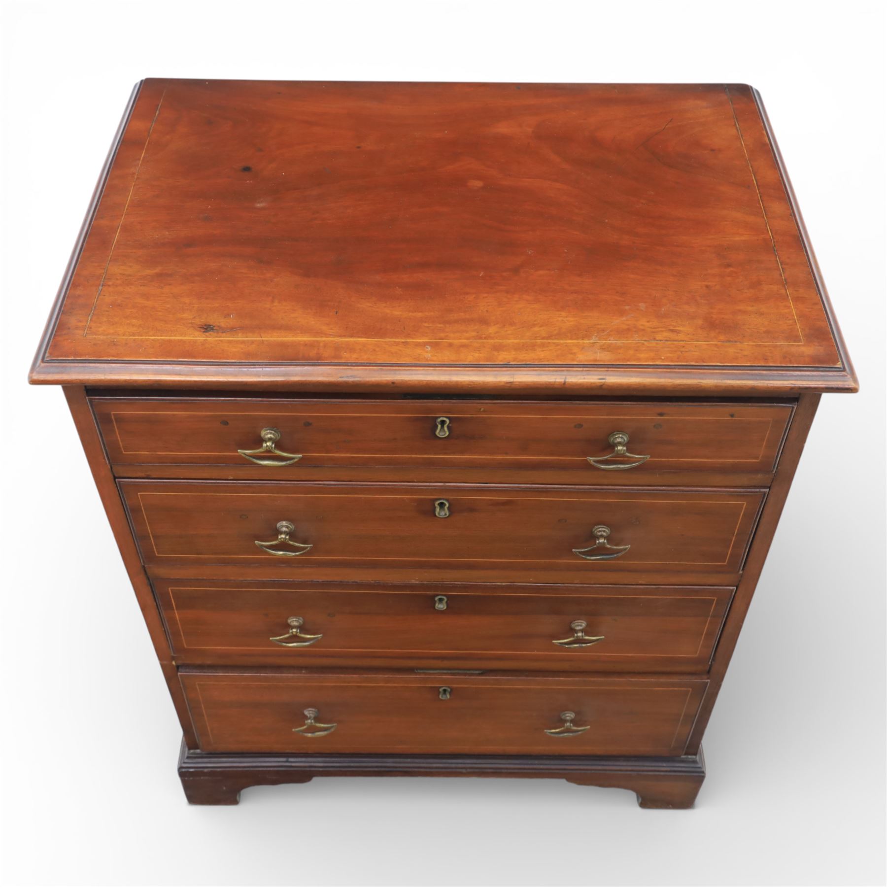Edwardian mahogany bachelor chest with inlay, the rectangular crossbanded top with fine stringing over a graduated arrangement of four drawers fitted with brass swan neck handles, standing on a moulded plinth above bracket feet