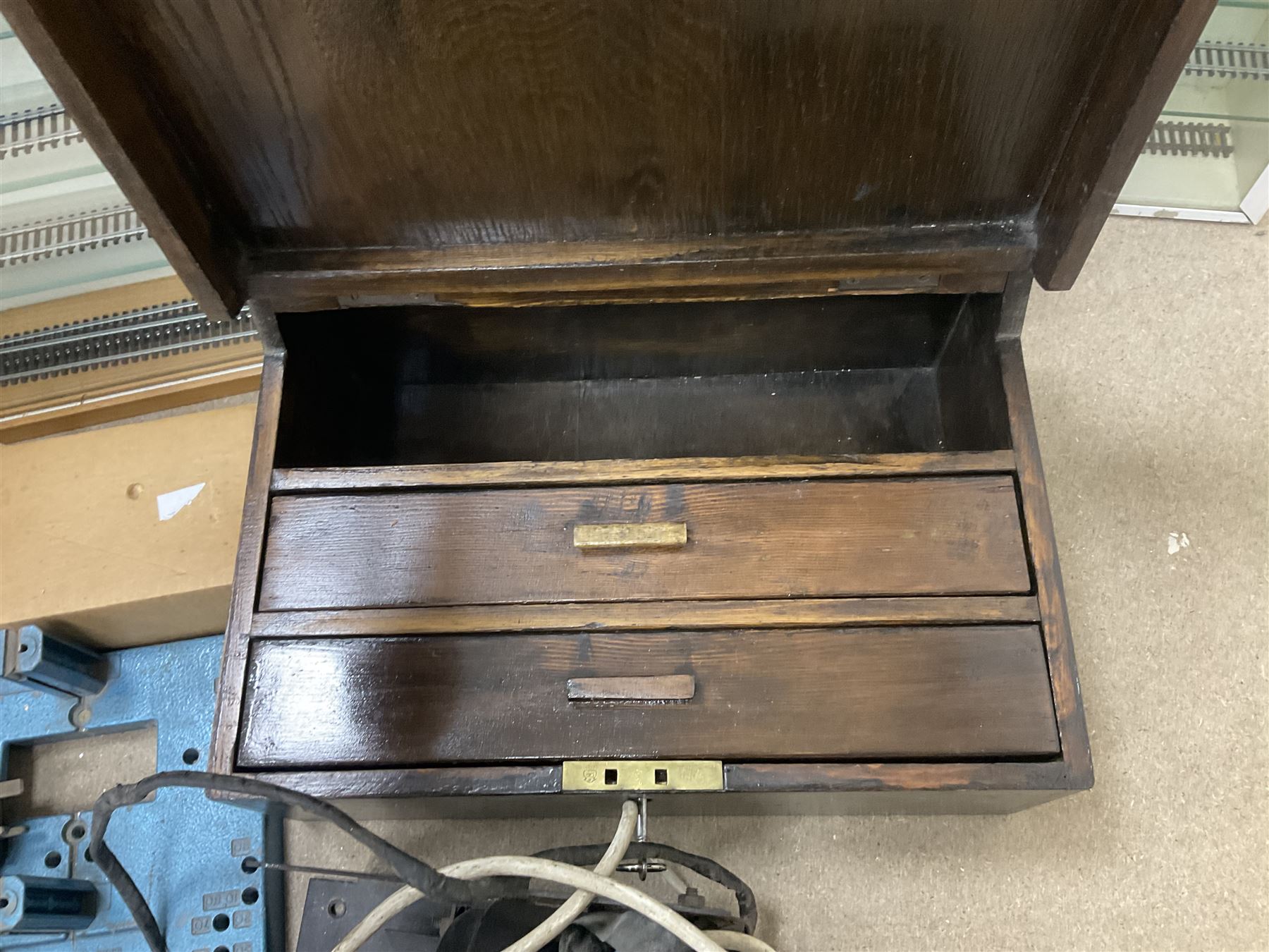 Six shelved cabinets for displaying ‘00’ gauge locomotives comprising plain plywood and white painted examples with track applied to various shelves, largest H63cm, W107cm, D27cm; Collection of tools for building model locomotives to include Weller PU-2D Soldering Pencil and Standard Tip Soldering Iron 20W/230V, Humbrol Modellers Airbrush, Power Supply Units and two wooden chests one of which housing a collection of tools including tweezers, scalping tools, wrenches etc 
