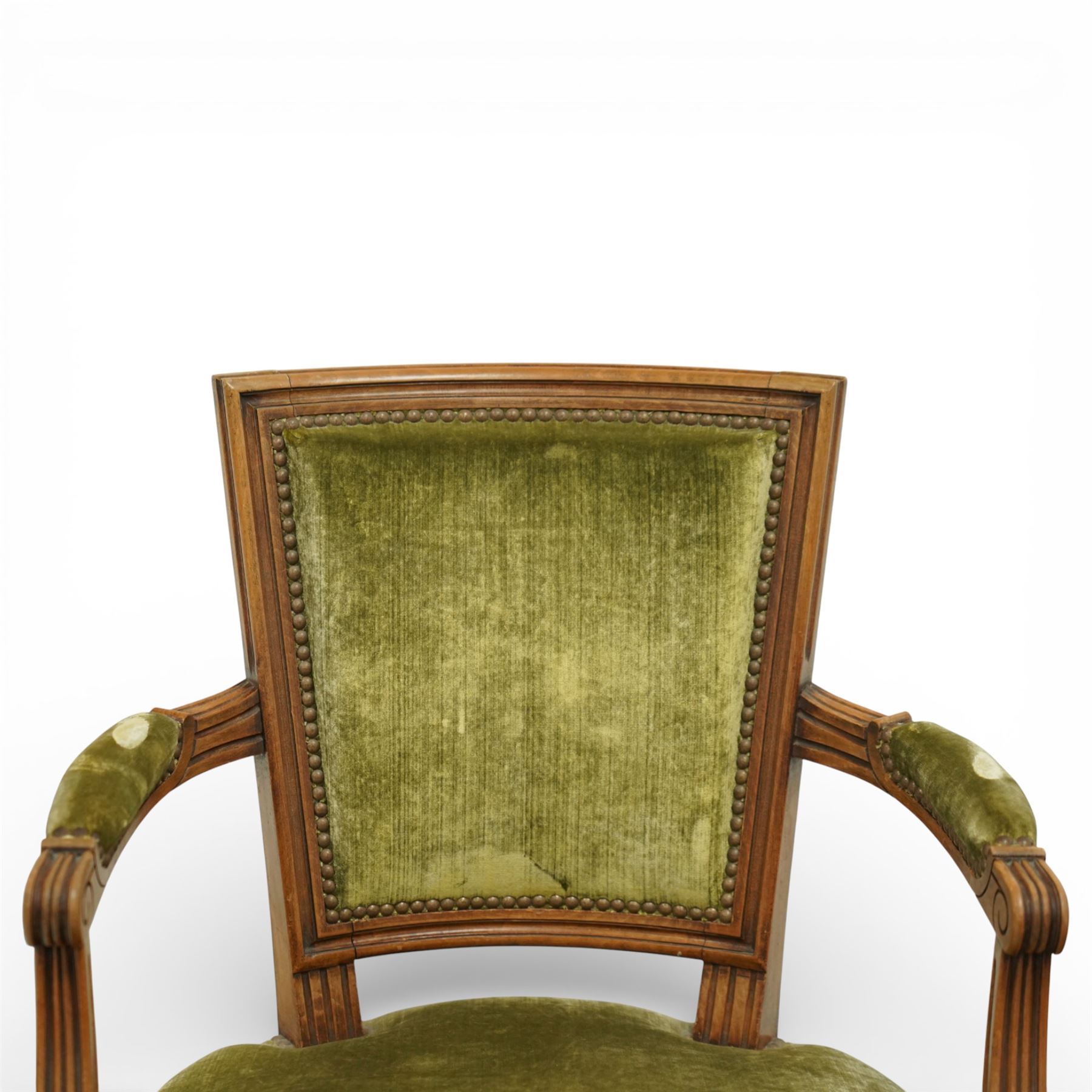 French Louis XVI style walnut armchairs, rectangular upholstered backs with nailhead trim, padded seats upholstered en suite, out-swept arms with upholstered pads, fluted supports with carved rosettes to the knees, on turned and fluted tapering legs
