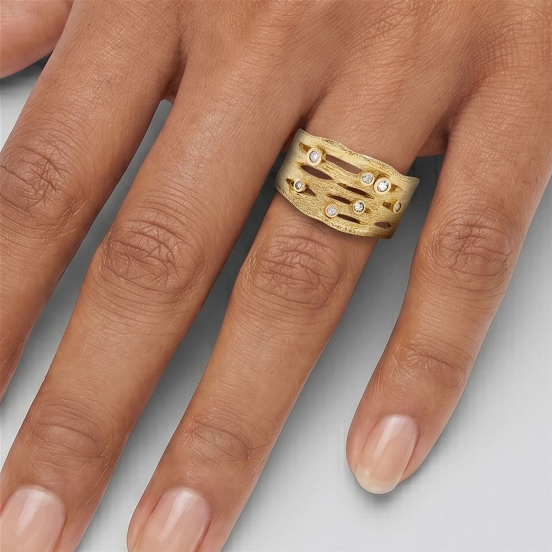 9ct gold diamond bubble ring, bezel set with seven round brilliant cut diamonds, in a textured pierced design setting, Birmingham 2008