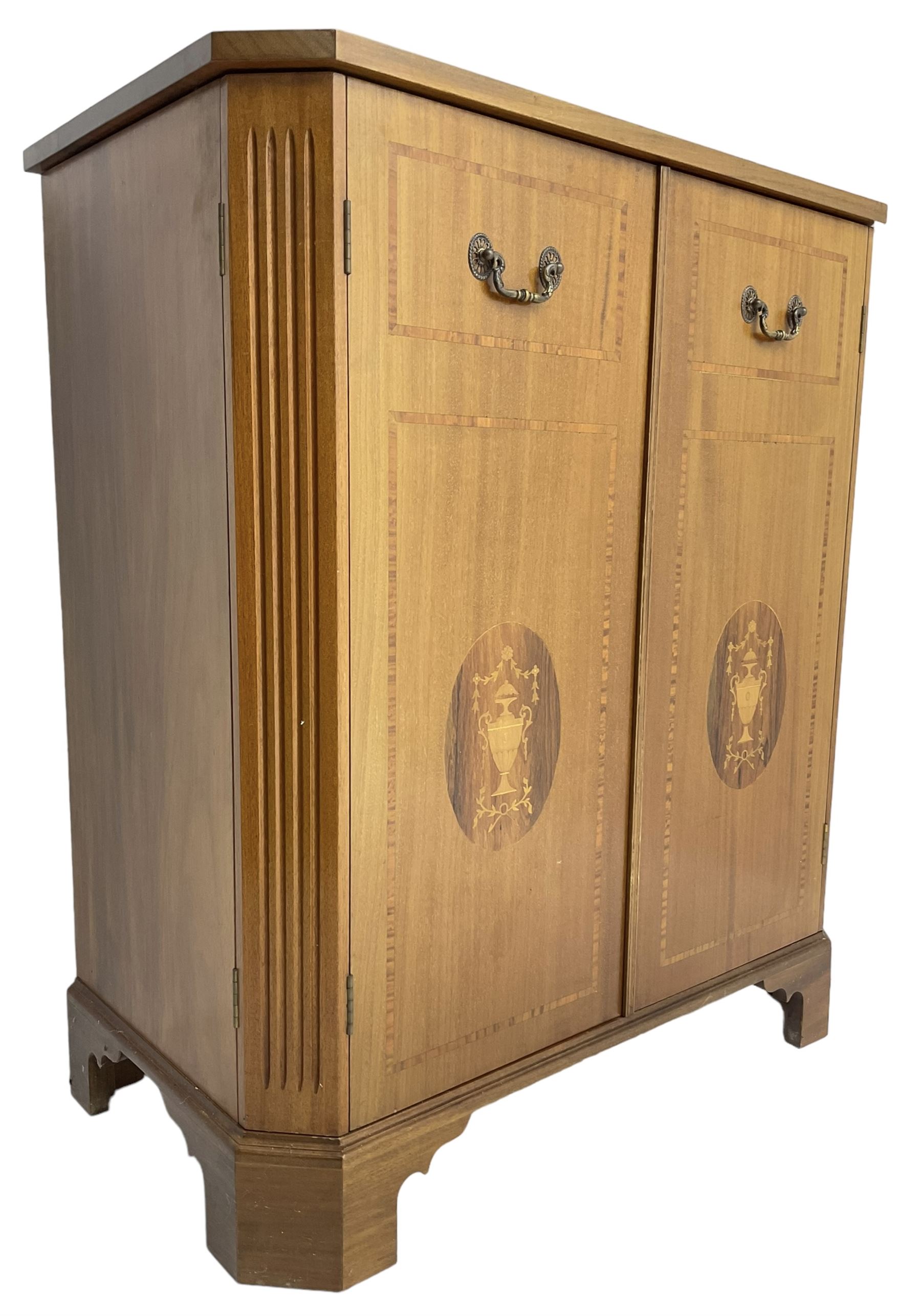 John More of Scarborough -  Edwardian Revival 'Canterbury Cabinet' inlaid mahogany cabinet, fitted with double cupboard decorated with urn motif inlays and banding, flanked by canted fluted uprights, on bracket feet