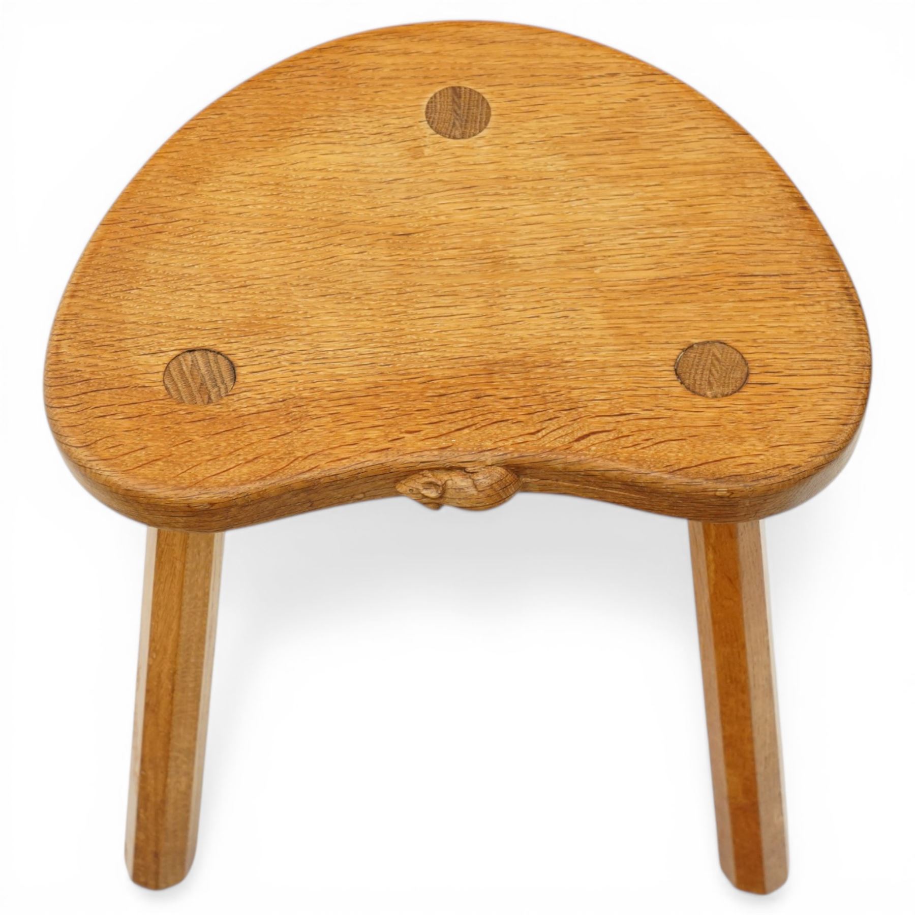 Mouseman - oak three-legged stool, dished kidney-shaped seat, raised on three octagonal splayed supports, with carved mouse signature, by the workshop of Robert Thompson of Kilburn