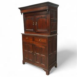 Early 19th century Welsh oak kitchen cupboard, the projecting cornice with twin cupboard doors, the rectangular base over two frieze drawers and panelled cupboard doors, raised on bracket feet, with fielded and arched panel variants to front and sides