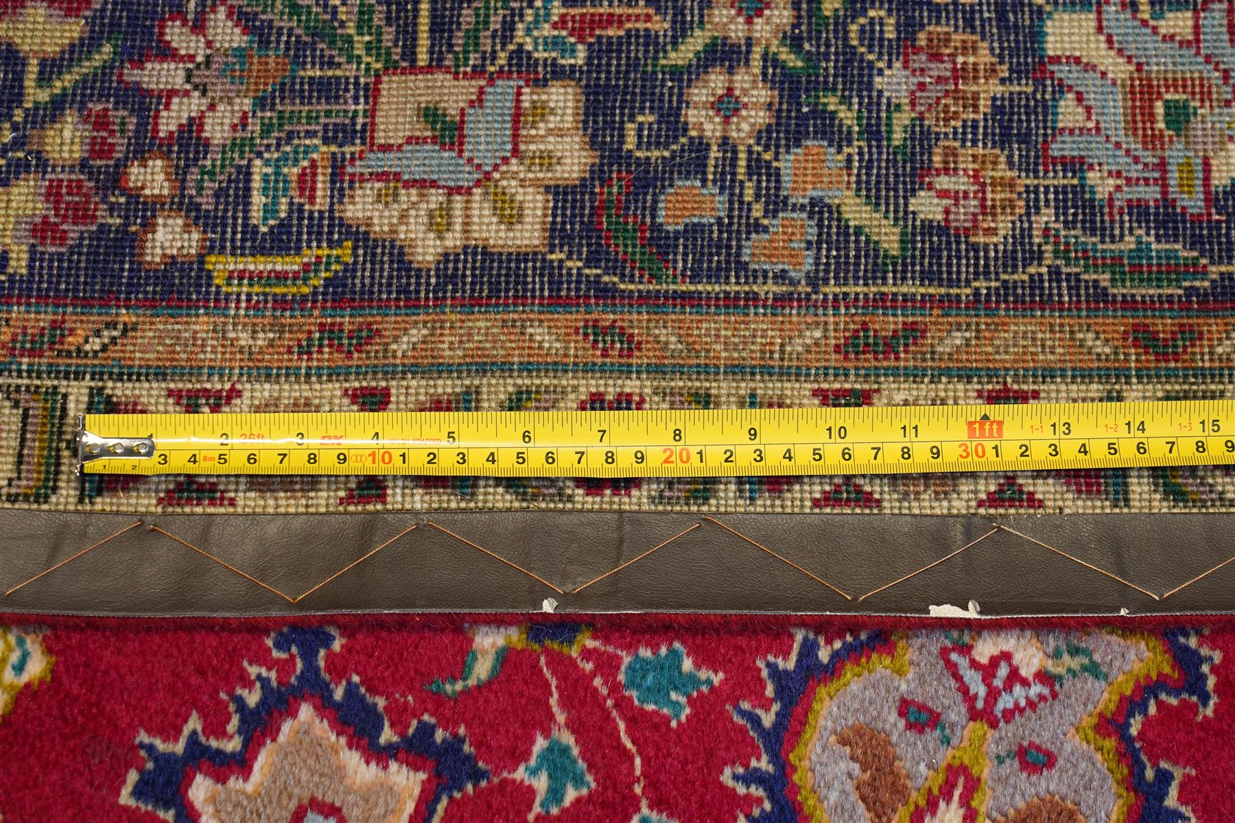 North West Persian Tabriz hand-knotted carpet, madder red field with a central cusped medallion issuing radiating pendants and an all-over design of scrolling arabesques, palmettes and flowering vinery enclosed by conforming spandrels, indigo main border of meandering floral vines and stylized palmettes, flanked by narrow guard stripes, cotton fringe ends 