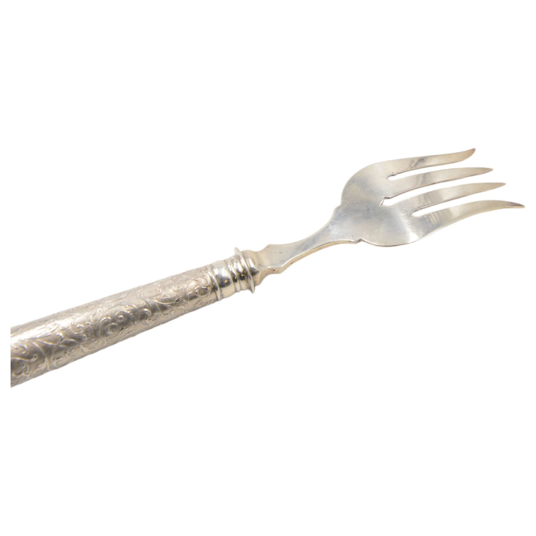 German silver handled four pronged fish serving fork, the tapering cylindrical handle with chased and repousse foliate decoration, engraved with monogram, stamped 800 with crescent and crown mark, L28cm

Notes: By vendor repute belonged to 7th Baron Brownlow 