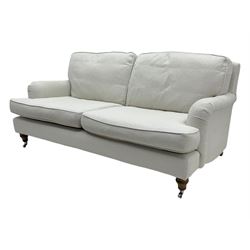 Contemporary sofa.com “Bluebell” two-and-a-half seat sofa, upholstered in pumice house basket weave linen cotton, featuring scroll arms, turned oak legs with bronze castors, and feather and fibre cushion interiors