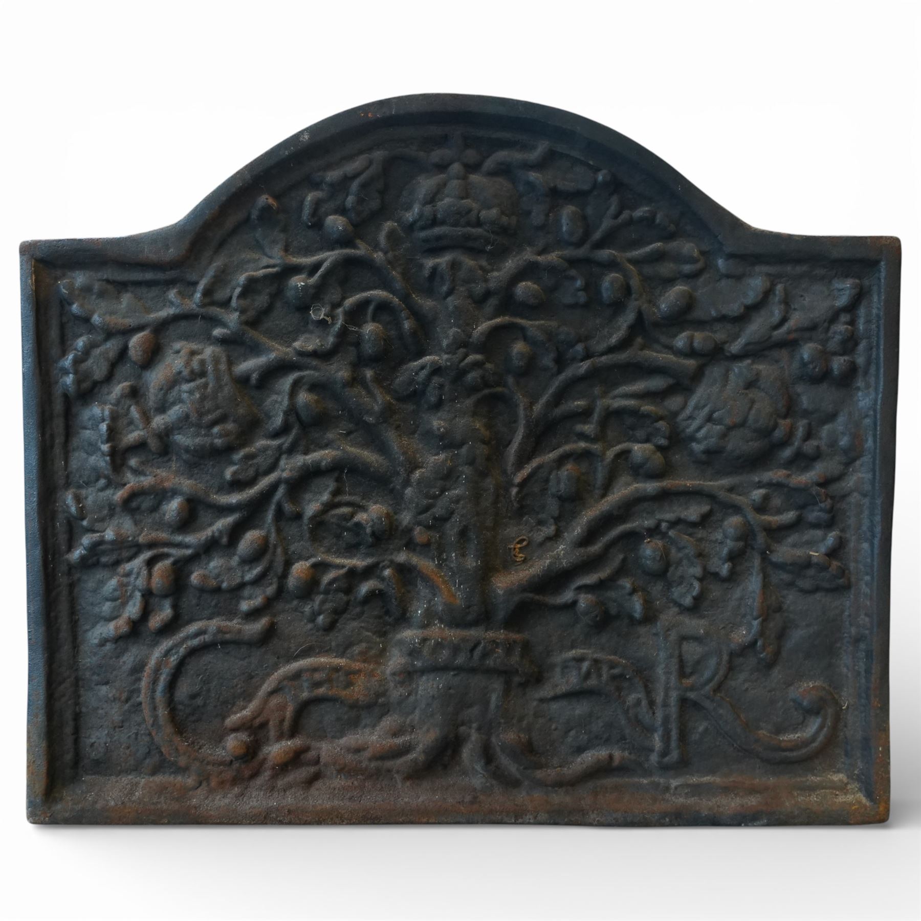 Early 20th century cast iron fireback, arched rectangular form cast in relief with a fruiting oak tree issuing acorns and leaves, surmounted by a crown, the trunk encircled by a ribbon tied cartouche with trailing scrollwork and foliate decoration, within a plain raised border