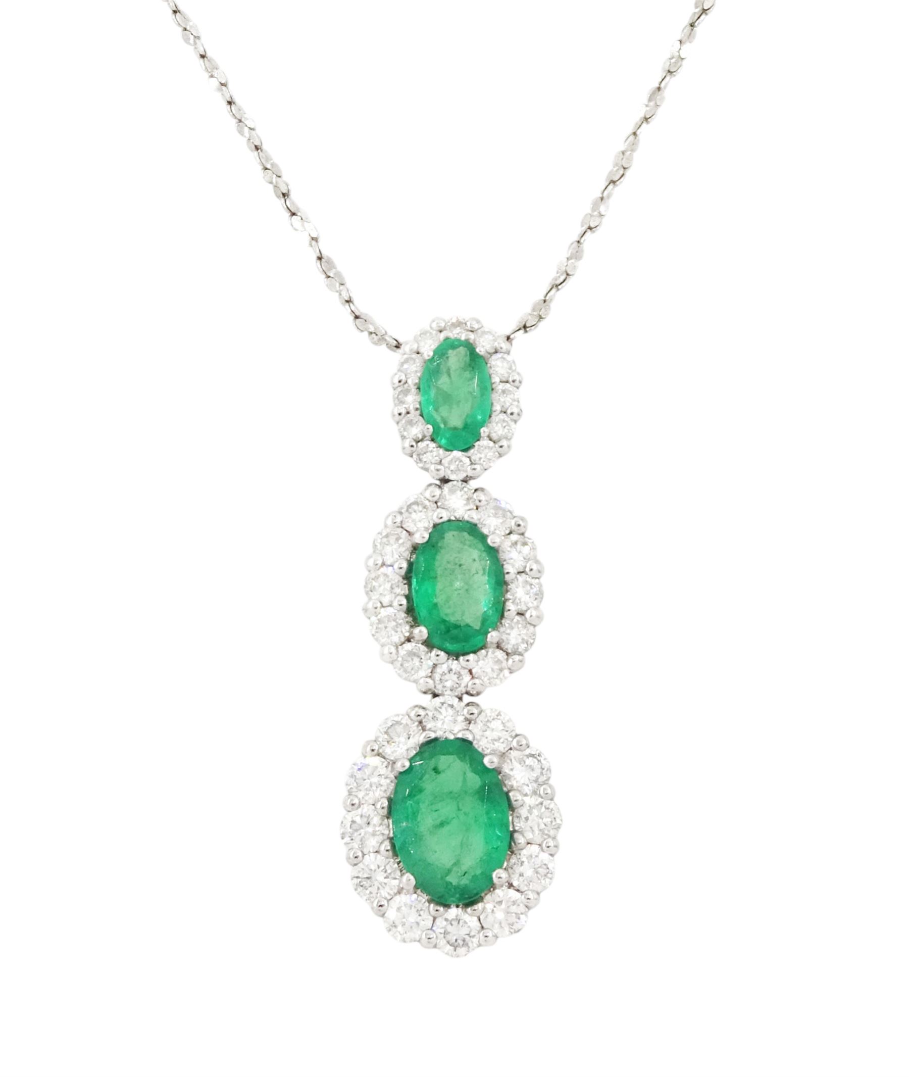 18ct white gold emerald and diamond cluster pendant, three graduating oval cut emeralds, each surrounded by round brilliant cut diamonds, Birmingham 2010, on a fine silver chain, total emerald weight approx 1.05 carat, total diamond weight approx 0.55 carat