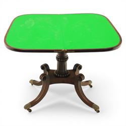 Early 19th century Regency mahogany fold over card table, the rounded rectangular top with brass line inlay enclosing green baize playing surface, crossbanded and strung exterior, with reeded edge above a gadrooned frieze, raised upon a turned column and four reeded sabre supports terminating in brass caps and castors