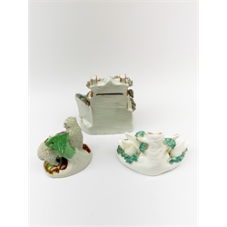 A 19th century Staffordshire money box in the form of a house, with encrusted detail, H17cm, together with two 19th century Staffordshire spill vases, the first detailed with two swans and signets, H12cm, the second with a sheep, H12.5cm, plus a selection of copper lustre ware. 