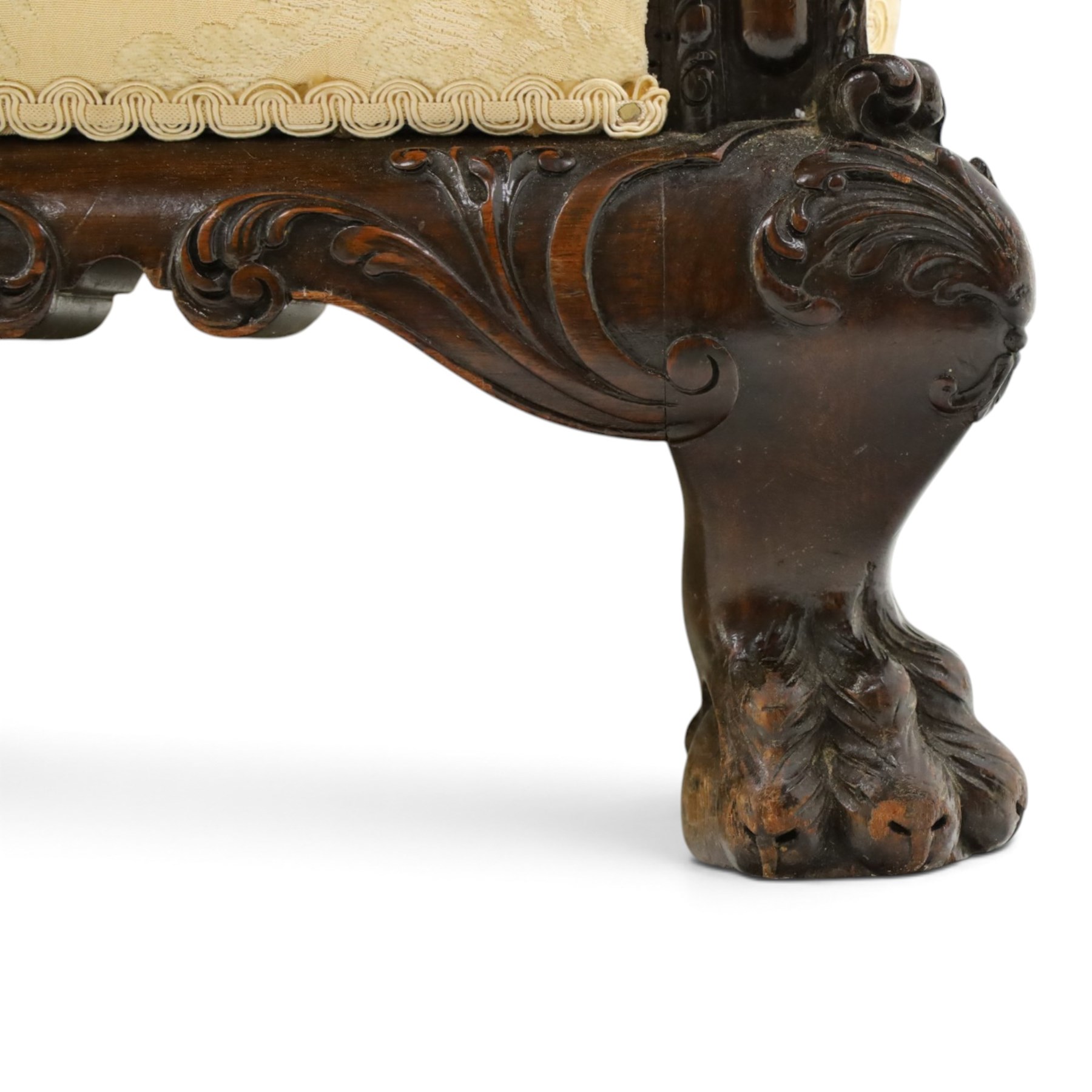 Quality Edwardian carved mahogany lounge suite comprising three-seater settee and pair of armchairs, the sofa with arched back over rolled arms and deep sprung seat, the arm terminals carved with acanthus rosette over gadroon and rope-twist moulding, the shaped apron carved and moulded with scrolling foliate acanthus motifs, terminating to four large front hairy paw and ball feet, upholstered in pale yellow foliate fabric with matching seat and scatter cushions (W200cm D105cm H73cm); the matching deep armchairs (W78cm D95cm H75cm)