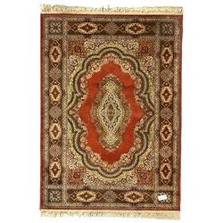 Persian design crimson ground rug, overall floral design, the field decorated with shaped spandrels and central medallion, the border with rectangular panelled decorated with floral motifs 