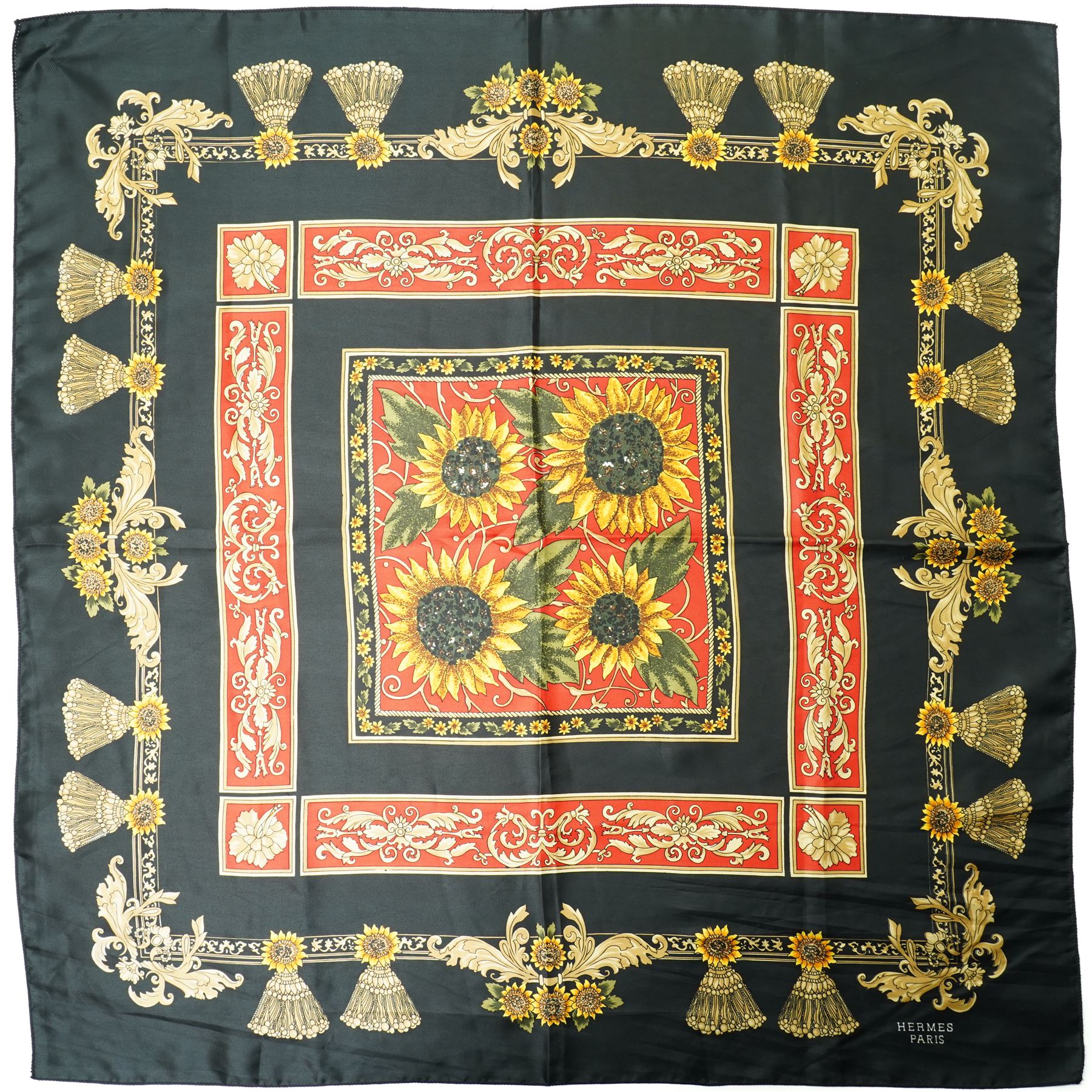 Hermès silk carré scarf, the black ground with central sunflower motif framed by ornate baroque panels and tassel borders in red, gold and yellow tones, signed Hermès Paris to the corner, hand-rolled edges, 90cm x 90cm