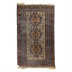 Baluchi design wool rug, with three geometric medallions on a cream field, enclosed by mul...