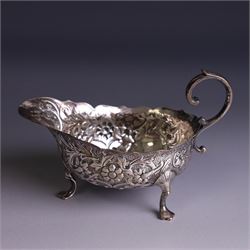 Victorian silver sauceboat, of typical form with embossed floral and foliate decoration, hallmarked London 1886, together with a miniature silver trophy and silver pickle fork, both hallmarked, trophy H7.5cm