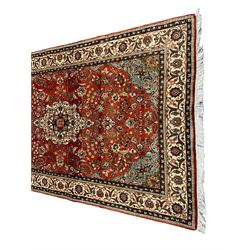 Small Persian Kashan crimson ground rug, the central interlaced medallion surrounded by scrolling foliate branches and stylised plant motifs, scrolling border with guard bands