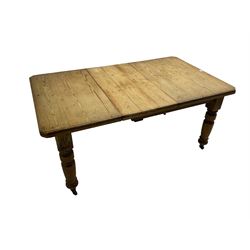 Late Victorian pine extending dining table, rectangular moulded top with canted corners and additional leaf, on turned supports with brass castors 