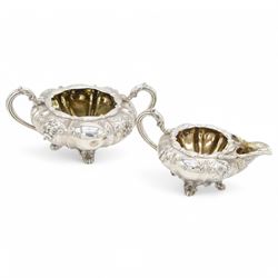 William IV silver twin handled sucrier and milk jug, each of circular bellied form, embossed with floral decoration, upon four pad scroll feet, hallmarked London 1831, maker's marks CE, including handles H10cm