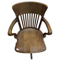 Early 20th century swivel office desk chair, shaped bar back over vertical rails, dished seat, on four splayed supports