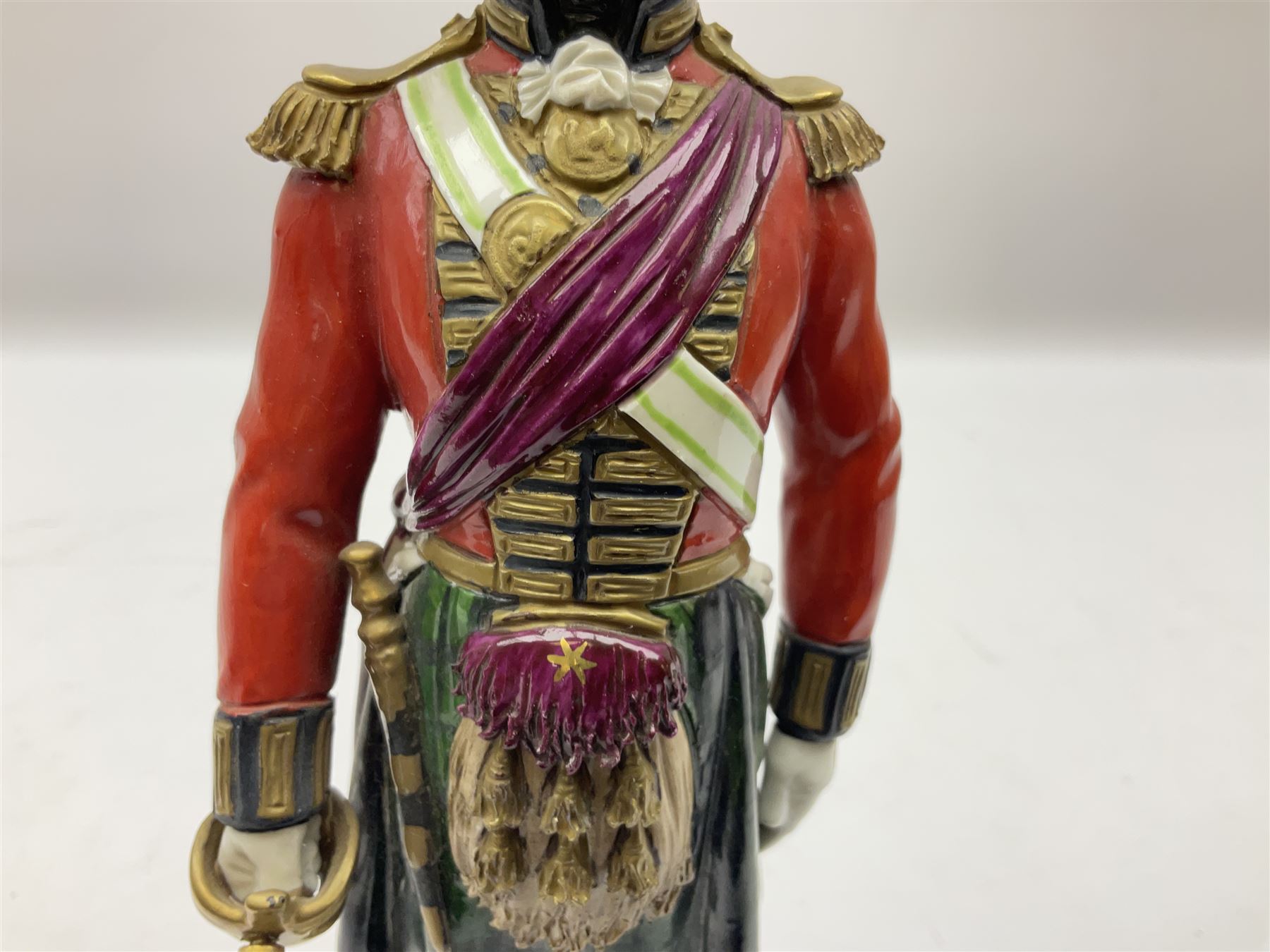 Sitzendorf figure, The Black Watch officer, c1815 standing to attention in full dress with sword, blue factory marks beneath, H28cm