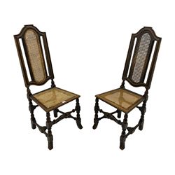 Pair Victorian high back hall chairs in the Carolean style, moulded frames, cane work seat and back, turned supports terminating at splayed lobe carved feet, turned stretcher rails 