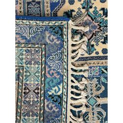 Morrocan single weft blue ground rug, the field segmented into a grid of ten rectangular panels, bordered by a series of guard bands with repeating floral and geometric patterns with interlocking vines and rosettes, the edges finished with a fringe of twisted tassles