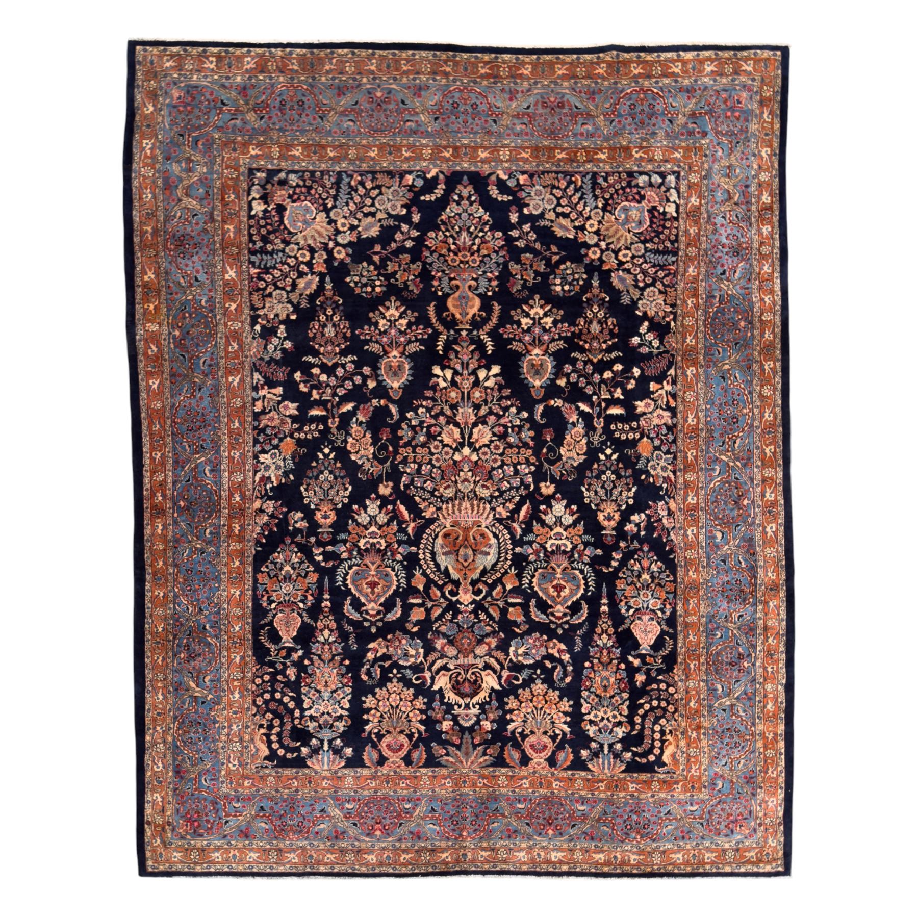 Northeastern Persian Meshed carpet, the deep navy field with a symmetrical floral arrangement of stylised flowerheads, palmettes and scrolling vines issuing from a central urn, enclosed by broad rust and blue borders of floral arabesques and lotus forms, from the region of Meshed