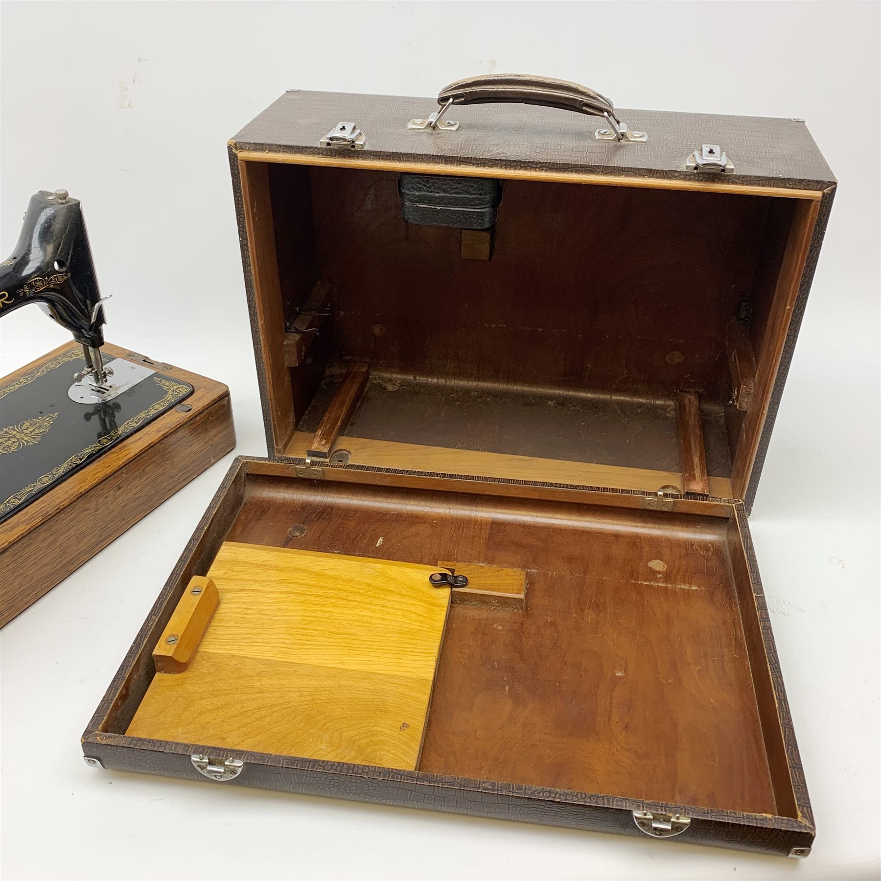 A vintage mid 20th Century cased Singer manual sewing machine, within faux crocodile carry case.
