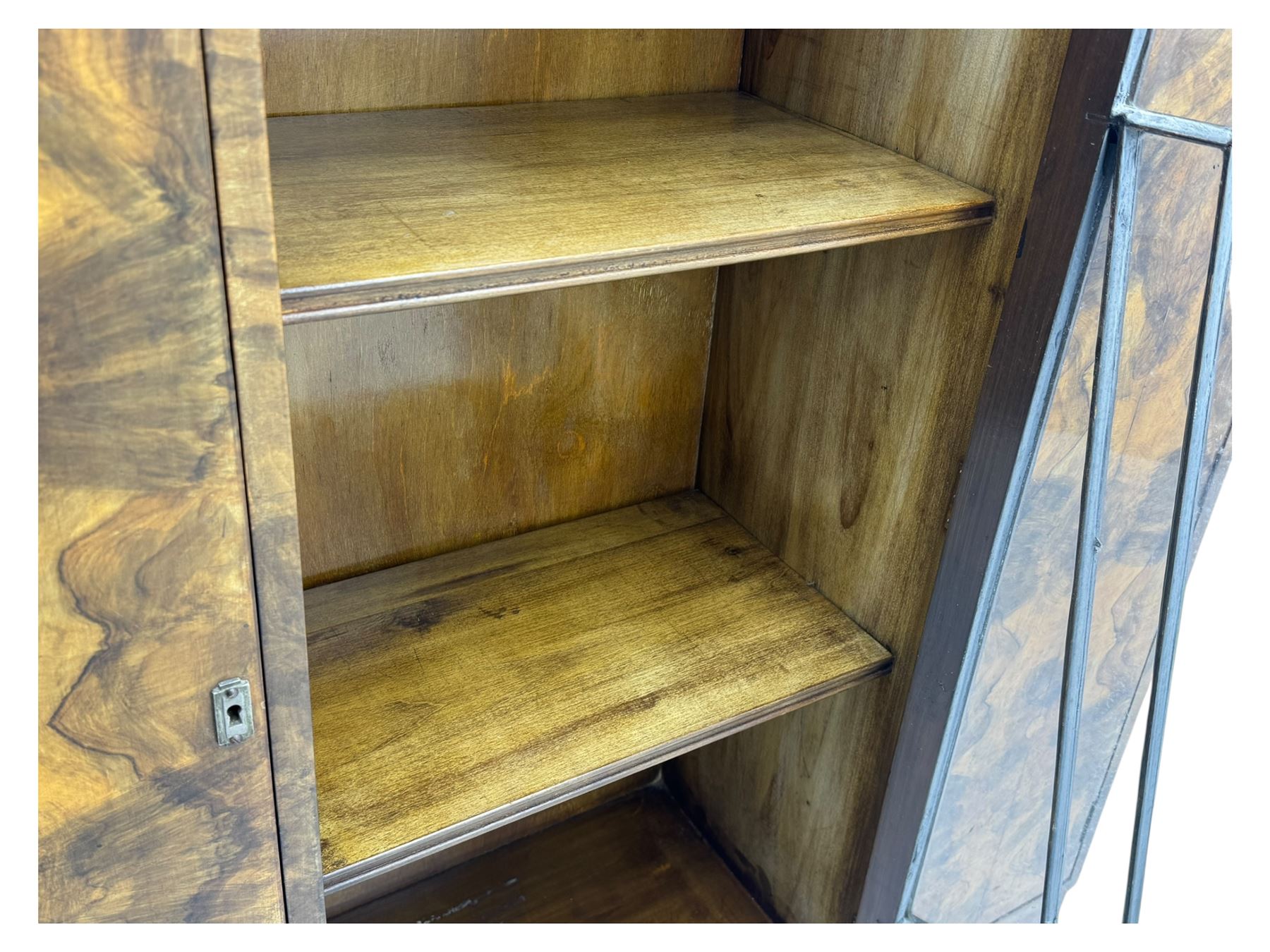 Art Deco burr walnut drinks cabinet, geometric central glazed astragal door enclosing two fixed shelves, flanked by symmetrical bookmatched veneered cupboards with drawers above 