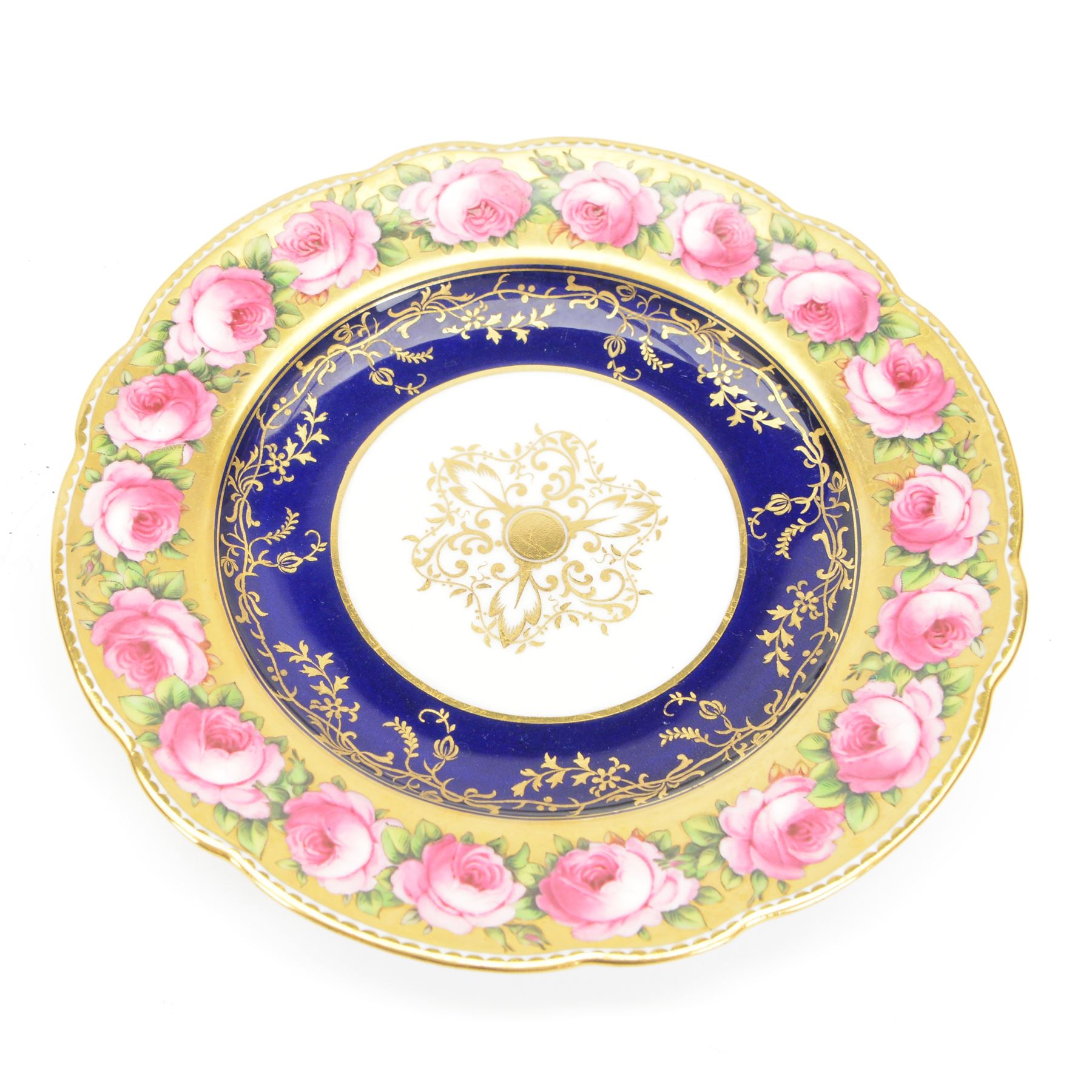 Early 19th century Coalport three handled goblet vase, shape no 114, and pair of plates, each hand painted with flowering pink roses upon a gilt band, against a dark blue ground heightened with trailing gilt tendrils, each marks beneath Coalport Swansea Period 1818, including handles vase H22.5cm, plates D23cm