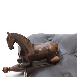 20th century saddle stool, wiht black leather seat, surmounted with carved horses, on an X-frame base with brass inlay