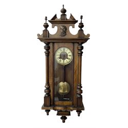 German- Late 19th century 8-day spring driven wall clock in a walnut and ebonised case, with a broken pediment and turned finials, fully glazed door with a visible pendulum and two part ivorine dial, chapter with roman numerals and minute track, rack striking movement sounding the hours and half hours on a coiled gong. With key .