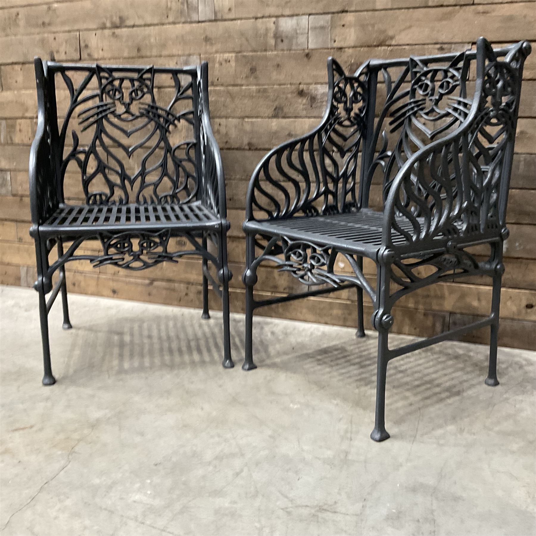 Richard Bawden (1936-2024): Pair of Cat design painted cast iron garden armchairs
