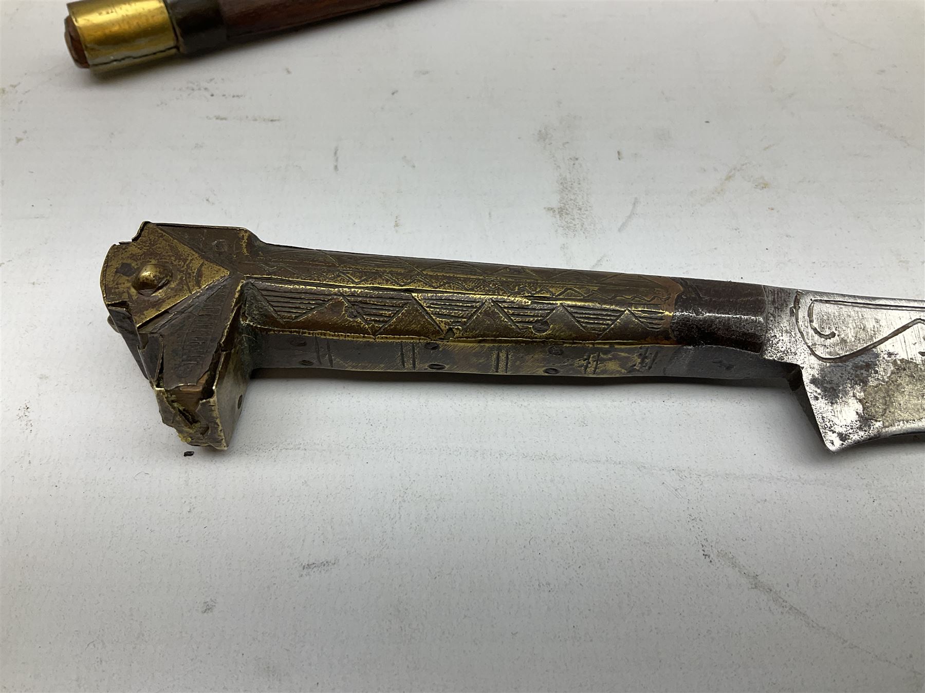 19th century Algerian Flyssa long knife, the 34cm single edged pointed decorative blade inset with yellow metal, chased brass grip with pommel as the snout of a stylised animal and carved hardwood scabbard L45cm overall