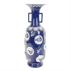 Chinses twin handled blue and white vase, decorated in relief with dragons amongst clouds ...