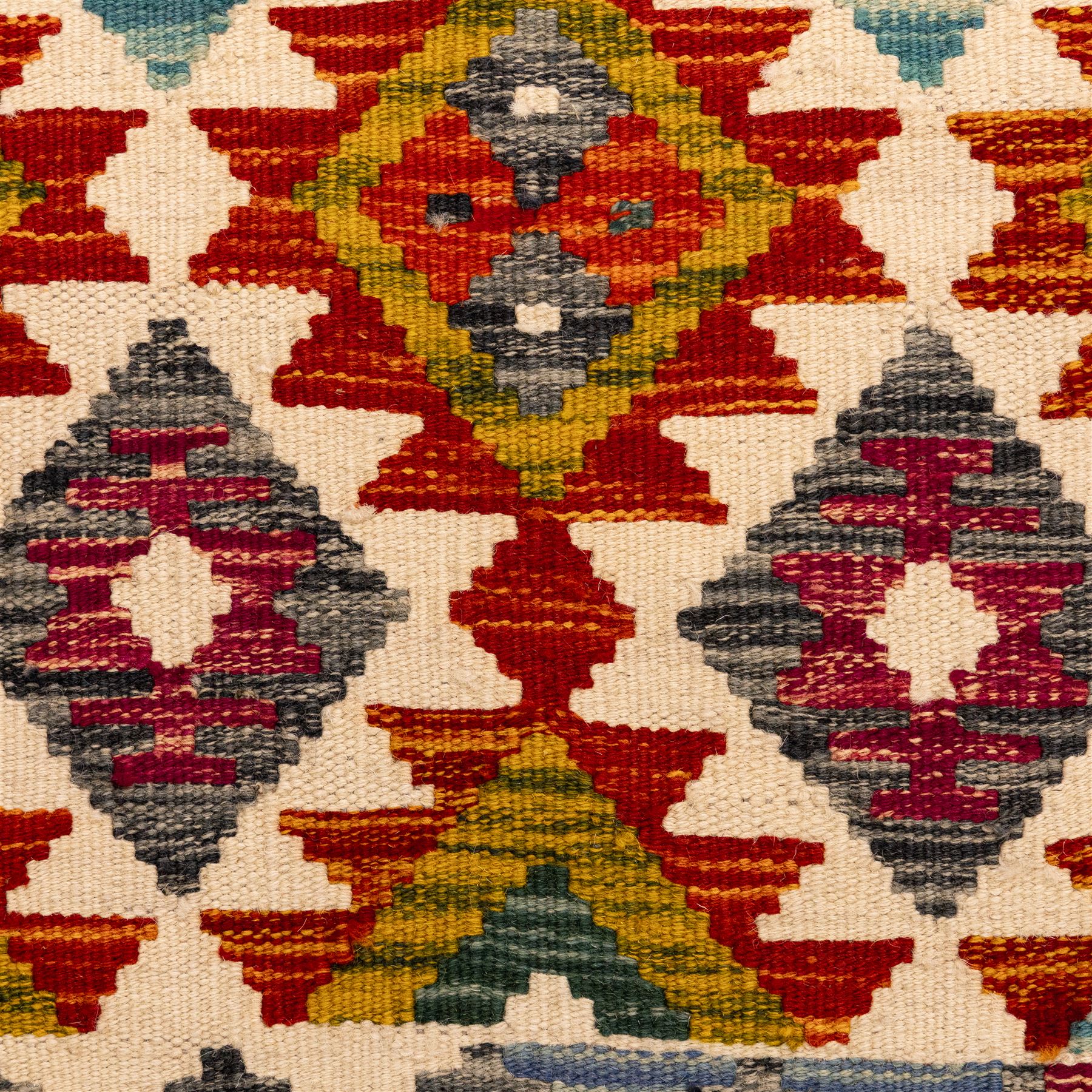 Afghan Chobi flatweave kilim runner, with a repeating stepped diamond medallion design in ivory, green, rust, teal, purple, indigo, and framed by chevron and geometric borders
