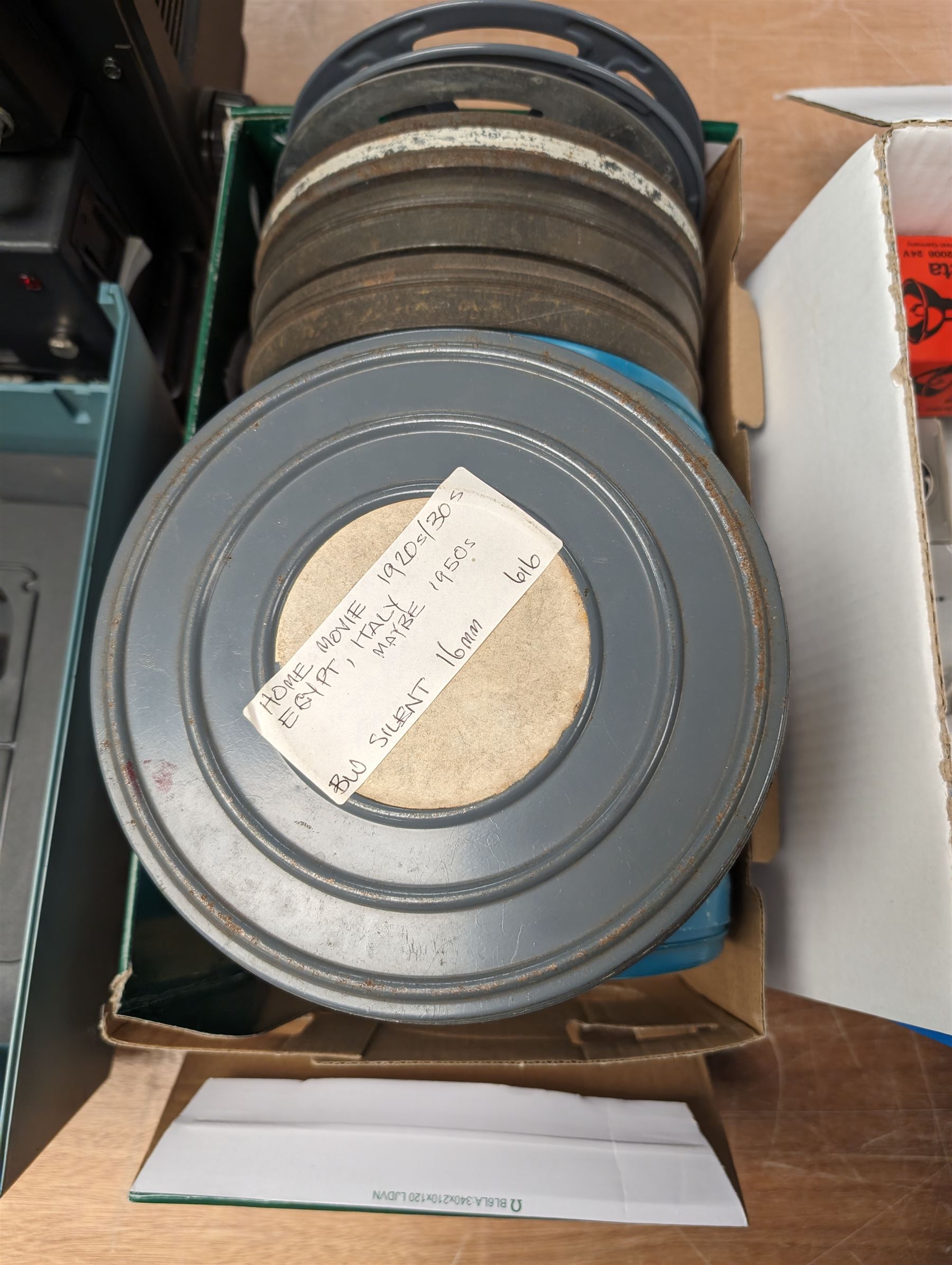 Bell & Howell TQ III 16mm film projector, together with lenses and spare projector lamps and a quantity of 16mm film reels, including Kellogg advert, Tex Avery cartoon and other film reels